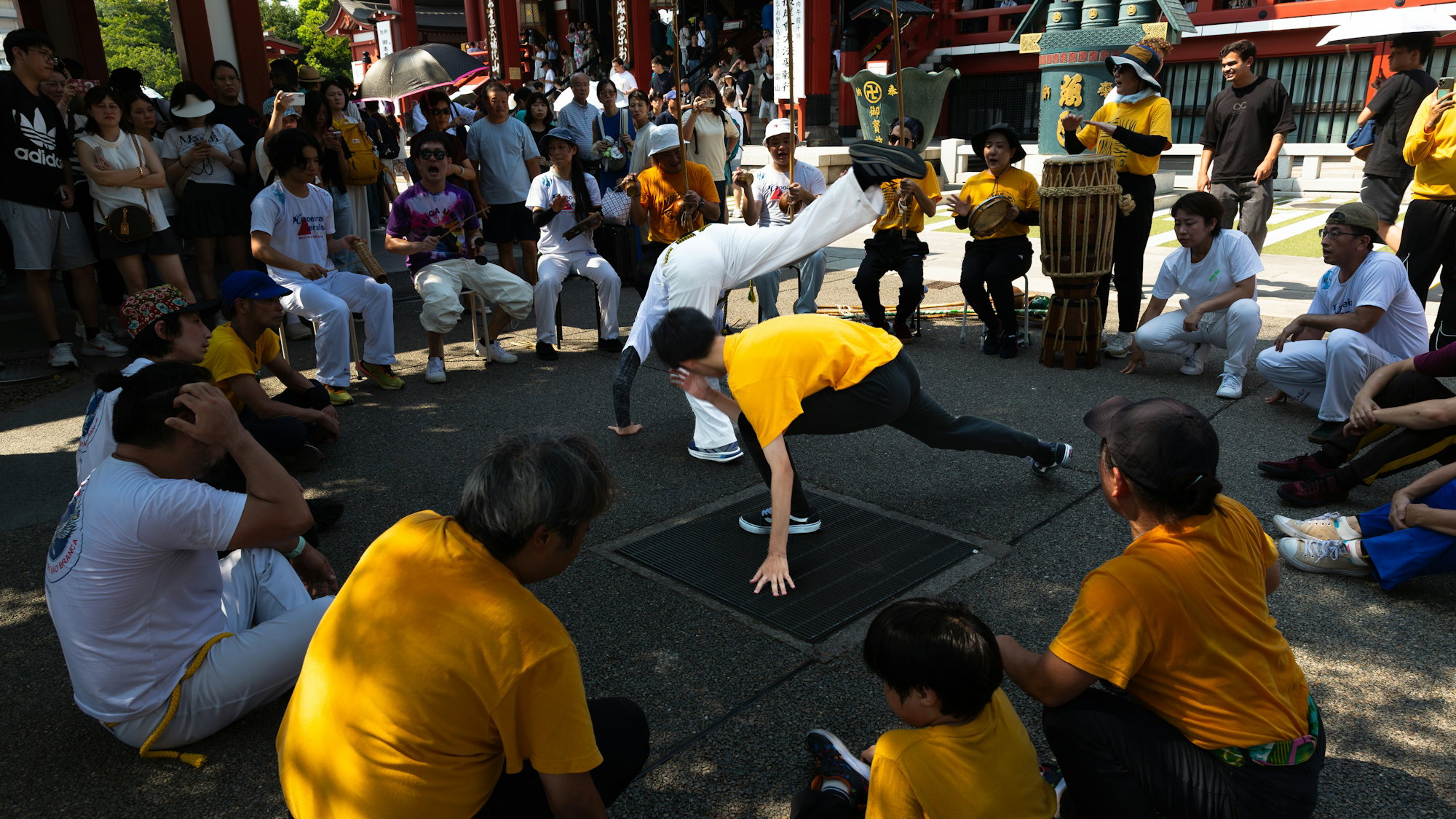 people-watch-capoeira-performers-in-a-circle-outdoors-.jpg People watch capoeira performers in a circle outdoors.